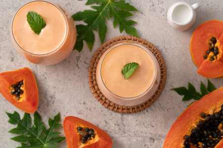 Fresh delicious papaya milk smoothie in glass cup on gray table background for tropical fruit design concept.の写真素材