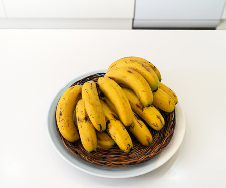 A bunch of fresh banana lie on the table in a modern kitchen, healthy life concept.の写真素材