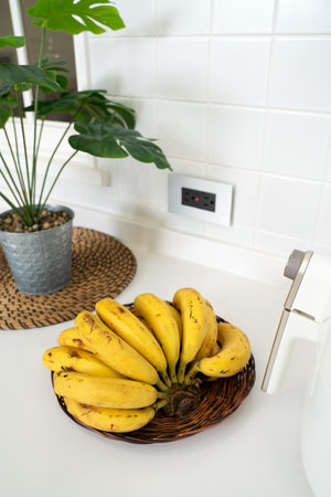 A bunch of fresh banana lie on the table in a modern kitchen, healthy life concept.の写真素材