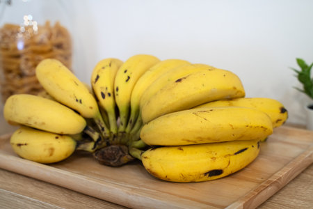 A bunch of fresh banana lie on the table in a modern kitchen, healthy life concept.の写真素材