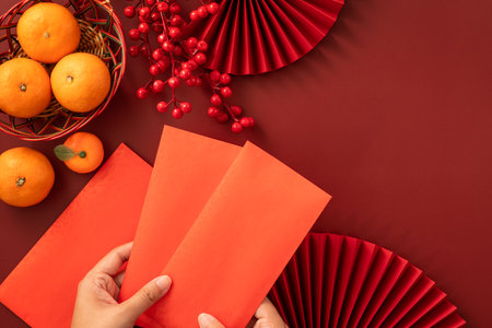 Chinese lunar new year background with fresh tangerine, red envelope, paper fan and decorations for Spring Festival.の写真素材