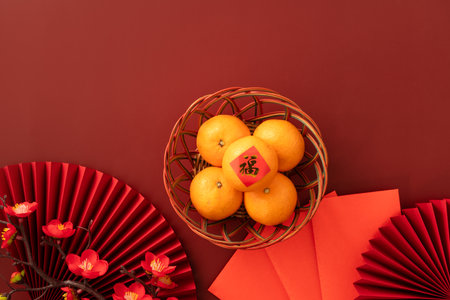 Chinese lunar new year background with fresh tangerine, red envelope, paper fan and decorations for Spring Festival and the word means fortune.の写真素材