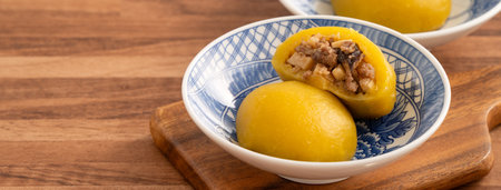 Homemade sweet potato yam bun with ground pork meat, mushroom and chopped bamboo shoot fillings inside in a bowl on wooden table background.の写真素材