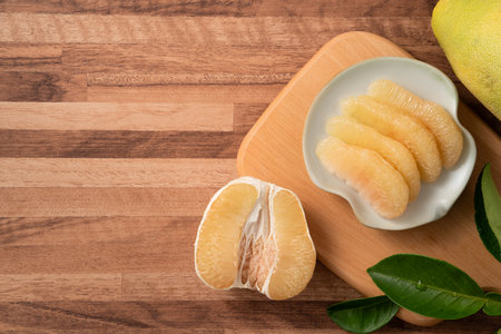 Fresh peeled pomelo with leaf on wooden table background for Mid-Autumn Festival fruit.の写真素材