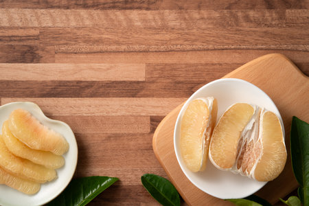 Fresh peeled pomelo with leaf on wooden table background for Mid-Autumn Festival fruit.の写真素材
