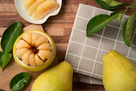Fresh peeled pomelo with leaf on wooden table background for Mid-Autumn Festival fruit.の写真素材