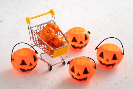 Halloween autumn shopping design concept with shopping cart and pumpkin on white table background.の写真素材