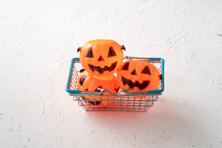 Halloween autumn shopping design concept with shopping cart and pumpkin on white table background.の写真素材