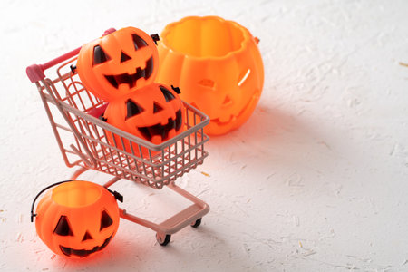 Halloween autumn shopping design concept with shopping cart and pumpkin on white table background.の写真素材