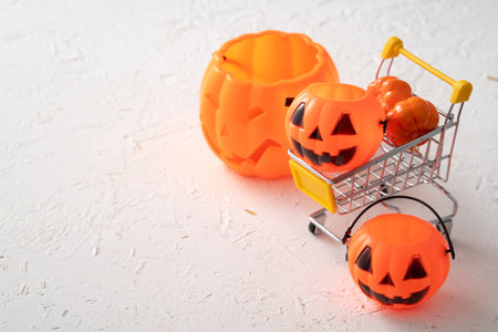 Halloween autumn shopping design concept with shopping cart and pumpkin on white table background.の写真素材