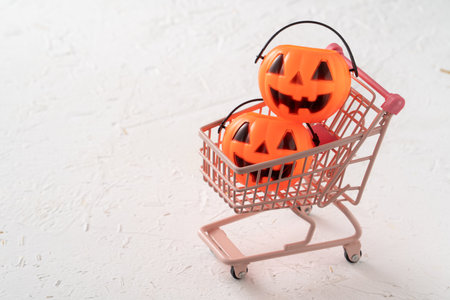 Halloween autumn shopping design concept with shopping cart and pumpkin on white table background.の写真素材