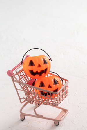 Halloween autumn shopping design concept with shopping cart and pumpkin on white table background.の写真素材