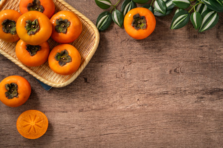 Fresh ripe sweet persimmon kaki fruit on wooden table background.の写真素材