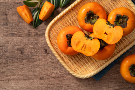 Fresh ripe sweet persimmon kaki fruit on wooden table background.の写真素材