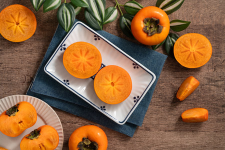 Fresh ripe sweet persimmon kaki fruit on wooden table background.の写真素材
