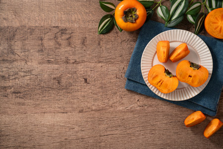 Fresh ripe sweet persimmon kaki fruit on wooden table background.の写真素材