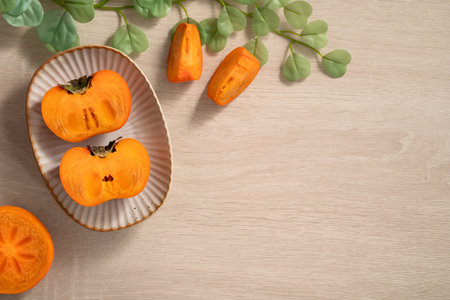 Fresh ripe sweet persimmon kaki fruit on wooden table background.の写真素材