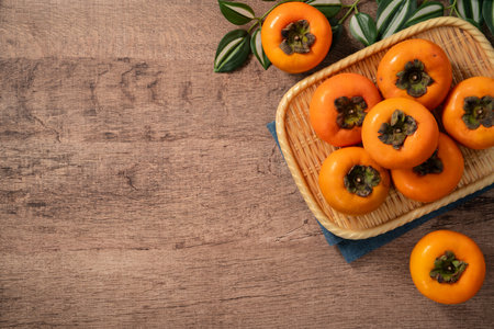 Fresh ripe sweet persimmon kaki fruit on wooden table background.の写真素材