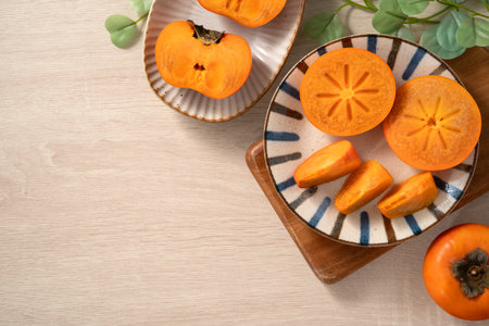 Fresh ripe sweet persimmon kaki fruit on wooden table background.の写真素材