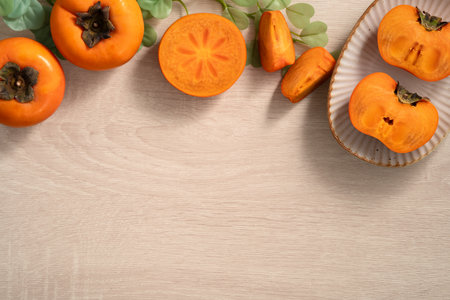 Fresh ripe sweet persimmon kaki fruit on wooden table background.の写真素材