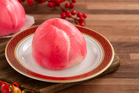 Pink Chinese peach birthday bun food longevity peach on wooden table background.の写真素材