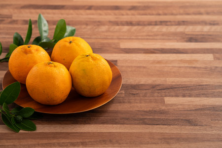 Fresh tangerine mandarin orange in a plate on wooden table background.の写真素材