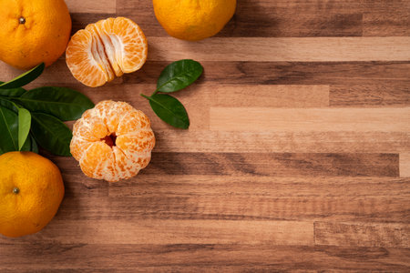 Fresh juice tangerine mandarin orange with leaf on wooden table background.