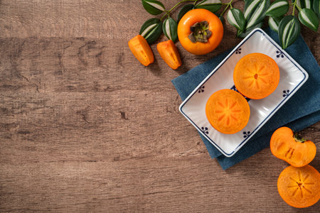Fresh ripe sweet persimmon kaki fruit on wooden table background.の写真素材