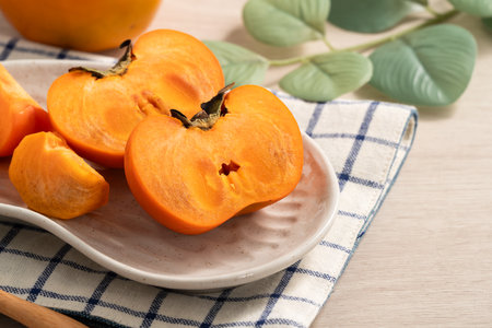 Fresh ripe sweet persimmon kaki fruit on wooden table background.の写真素材