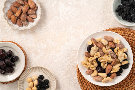 Flavored mixed nuts in bowls on white table background.