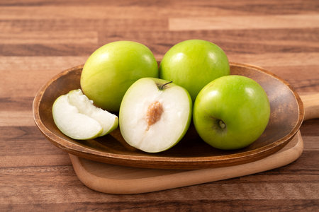 Fresh juicy delicious Taiwanese Milk Indian Jujube fruit in a basket on wooden table background.の写真素材
