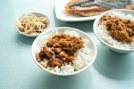 Braised pork belly meat rice, stewed pork over cooked rice with pan-fried milkfish beside.の写真素材