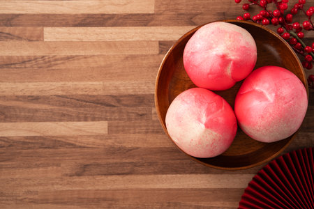Pink Chinese peach birthday bun food longevity peach shoutao on wooden table background.の写真素材