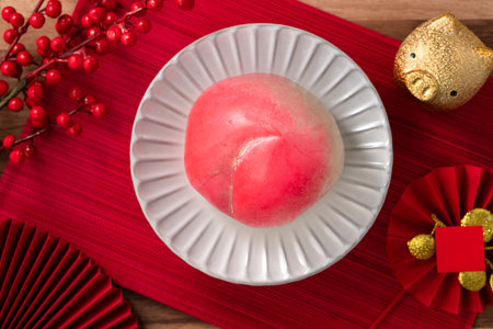 Pink Chinese peach birthday bun food longevity peach shoutao on wooden table background.の写真素材