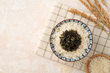 A bowl of fluffy white rice topped with seasoned seaweed and sesame.の写真素材
