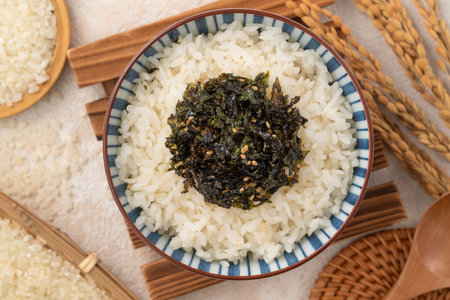 A bowl of fluffy white rice topped with seasoned seaweed and sesame.の写真素材