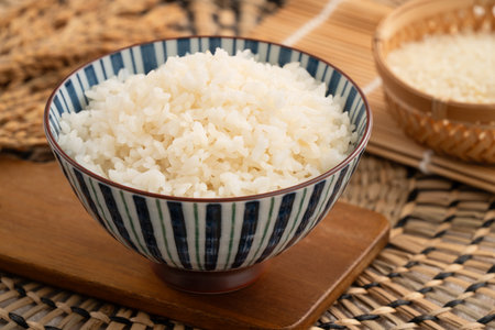 A bowl of freshly cooked steamed white rice, soft, fluffy, and slightly glossy on white table background.の写真素材