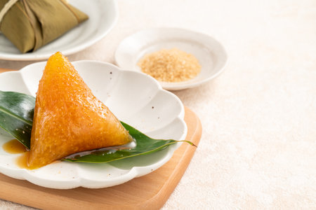 Golden alkaline zongzi rice dumpling served on a leaf, a classic treat for the Dragon Boat Festival.の写真素材