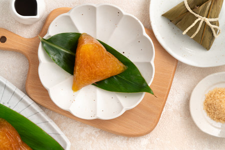 Golden alkaline zongzi rice dumpling served on a leaf, a classic treat for the Dragon Boat Festival.の写真素材