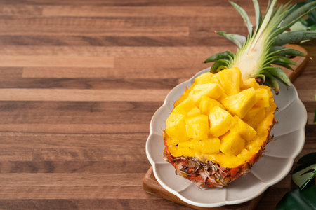 Juicy pineapple chunks arranged in a halved pineapple bowl with tropical leaves in the background.