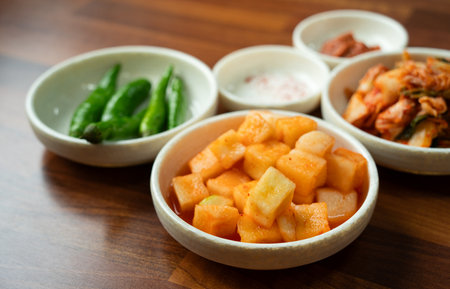 Close-up of cubed radish kimchi served in a black dish, traditional Korean gourmet side dish.の写真素材