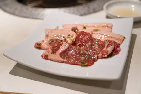 Marinated pork belly slices being grilled.の写真素材