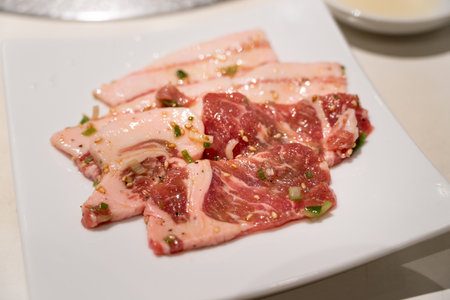 Marinated pork belly slices being grilled.の写真素材