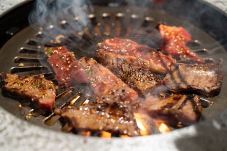 Marinated beef meat slices being grilled in BBQ restaurant.の写真素材