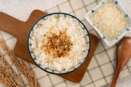 A bowl of fluffy white rice topped with sprinkle rice seasonings.の写真素材