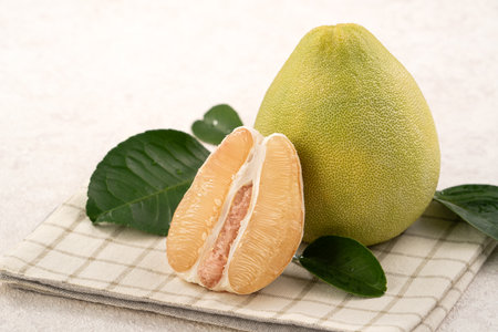 Fresh peeled pomelo with leaf on white table background.の写真素材