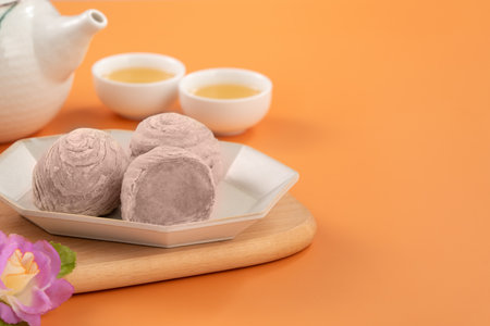 Taro puff pastries for Mid Autumn Festival holiday afternoon tea on orange table background.の写真素材