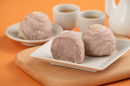Taro puff pastries for Mid Autumn Festival holiday afternoon tea on orange table background.の写真素材