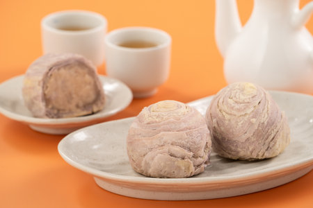 Taro puff pastries for Mid Autumn Festival holiday afternoon tea on orange table background.