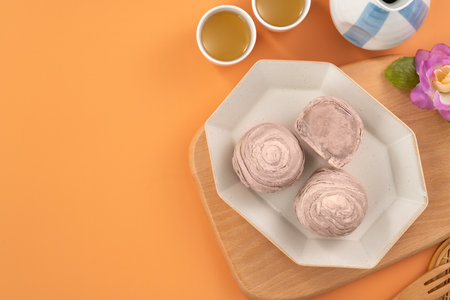 Taro puff pastries for Mid Autumn Festival holiday afternoon tea on orange table background.